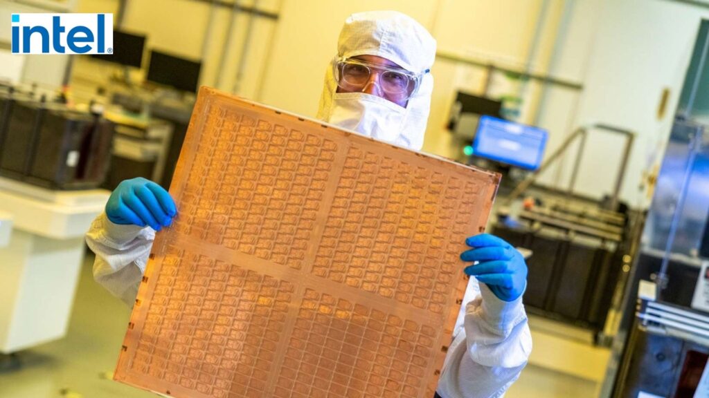 A picture from Intel showing an engineer in a lab suit holding a large glass panel with chips packaged on it.